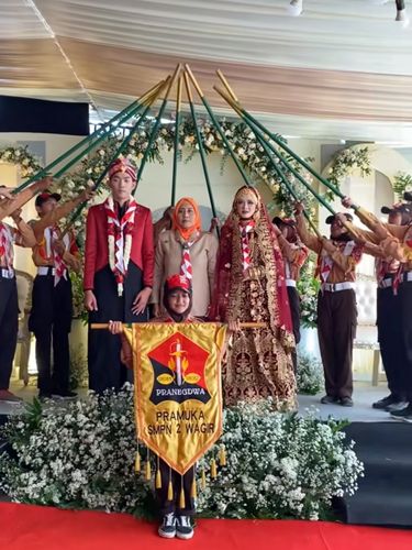 Pengantin ini mengenakan busana bernuansa India, tradisi adat Jawa dan juga menjalani prosesi tongkat pora Pramuka. Acara pernikahan tersebut langsung viral di TikTok.