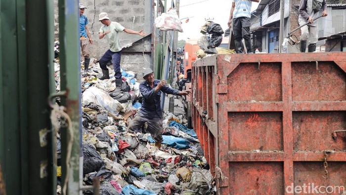 Petugas membersihkan tumpukan sampah di TPS Cimahi