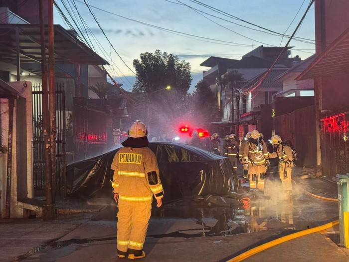 Proses pemadaman mobil listrik BYD Seal yang terbakar di dalam garasi rumah di Jakbar.