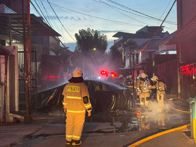 Proses pemadaman mobil listrik BYD Seal yang terbakar di dalam garasi rumah di Jakbar.