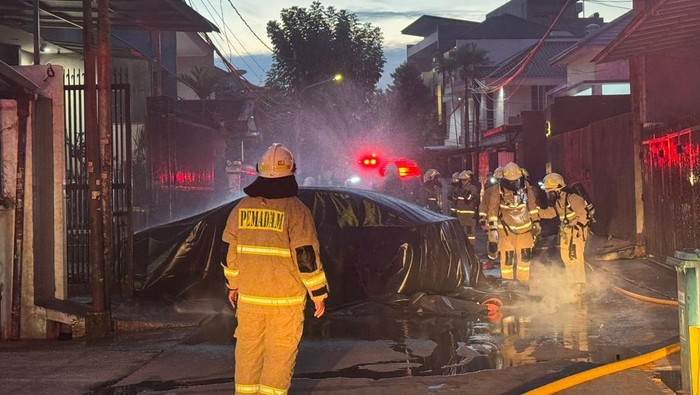 Proses pemadaman mobil listrik BYD Seal yang terbakar di dalam garasi rumah di Jakbar.