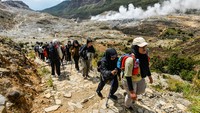 Pendaki menaiki bukit di samping kawah di Taman Wisata Alam (TWA) Gunung Papandayan di Kabupaten Garut, Jawa Barat, Senin (12/5/2025).