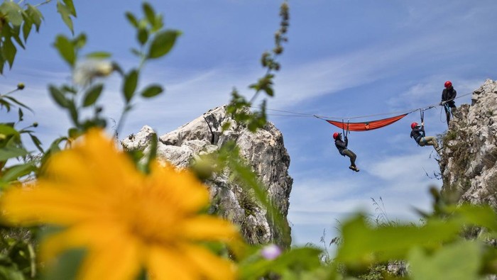 Wisatawan bergelantung di tempat tidur gantung (hammock) saat berwisata di Tebing Hawu, Padalarang, Kabupaten Bandung Barat, Jawa Barat, Senin (12/5/2025). Wisata ekstrem hammock di ketinggian sekitar 50 meter dari atas tanah dengan panorama perbukitan dan persawahan tersebut menjadi salah satu kegiatan wisata luar ruang favorit masyarakat untuk mengisi libur panjang Hari Raya Waisak 2025. ANTARA FOTO/Abdan Syakura/Spt.