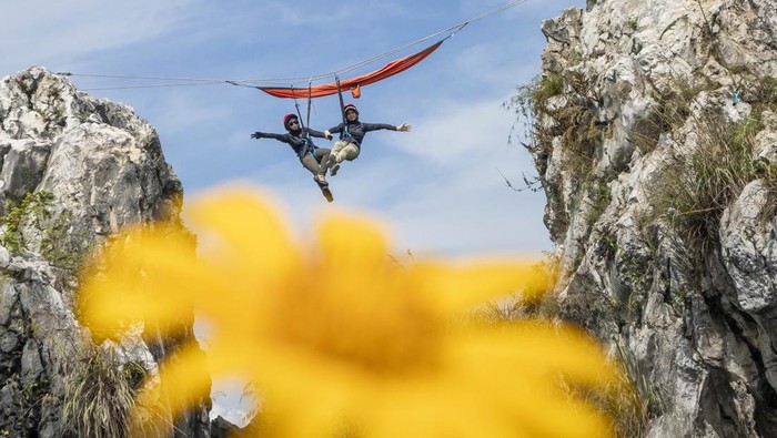 Wisatawan bergelantung di tempat tidur gantung (hammock) saat berwisata di Tebing Hawu, Padalarang, Kabupaten Bandung Barat, Jawa Barat, Senin (12/5/2025). Wisata ekstrem hammock di ketinggian sekitar 50 meter dari atas tanah dengan panorama perbukitan dan persawahan tersebut menjadi salah satu kegiatan wisata luar ruang favorit masyarakat untuk mengisi libur panjang Hari Raya Waisak 2025. ANTARA FOTO/Abdan Syakura/Spt.