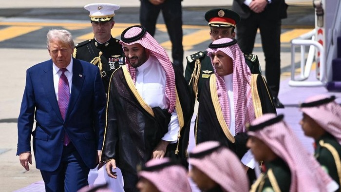 Saudi Crown Prince Mohammed bin Salman (C) walks with US President Donald Trump (L) upon his arrival in Riyadh on May 13, 2025. (Photo by Brendan SMIALOWSKI / AFP)