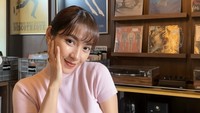Wanita kelahiran Tasikmalaya ini sedang di melihat-lihat koleksi piringan hitam. Momen santainya juga ditemani segelas es matcha. Foto: Instagram dindakirana.s