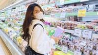 Tahun 2022, Dinda pamer momen belanja di supermarket masih mengenakan masker. Ia melihat-lihat rak buah segar sambil membawa segelas botol minuman. Foto: Instagram dindakirana.s