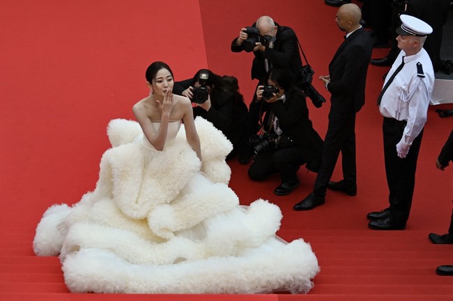 Tak kalah ‘heboh’, aktris China Wan QianHui dengan gaun strapless kuning yang memiliki rok megar seperti kumpulan bulu yang bertumpuk. Busana tersebut merupakan bagian dari koleksi adibusana desainer China Wang Feng. (Foto: AFP/ANTONIN THUILLIER)