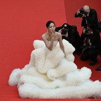 Tak kalah ‘heboh’, aktris China Wan QianHui dengan gaun strapless kuning yang memiliki rok megar seperti kumpulan bulu yang bertumpuk. Busana tersebut merupakan bagian dari koleksi adibusana desainer China Wang Feng. (Foto: AFP/ANTONIN THUILLIER)