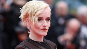 Julia Garner tampil dengan rambut pendek pirangnya yang khas, bergaun hitam dengan aksen warna kulit. (Foto: AFP/SAMEER AL-DOUMY)
