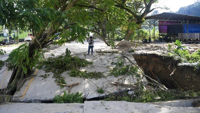 Jalan Nasional Amblas! Petugas melintasi jalan yang amblas di kawasan Jalan HAM Rifaddin, Loa Janan Ilir, Samarinda Seberang, Samarinda, Kalimantan Timur, Selasa (13/5/2025). Menurut petugas Balai Besar Pelaksanaan Jalan Nasional (BBPJN) Kalimantan Timur, jalan nasional akses utama penghubung Samarinda-Balikpapan itu terputus sekitar 15 meter pada Senin (12/5) malam sekitar pukul 21.15 WITA akibat curah hujan yang tinggi. ANTARA FOTO/M Risyal Hidayat/YU