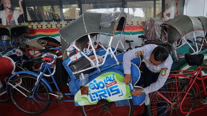 Petugas Dinas Perhubungan (Dishub) Kota Solo memasangi stiker reflektif untuk becak saat sosialisasi keselamatan berkendara di kantor Dishub Solo, Jawa Tengah, Rabu (14/5/2025). Kegiatan itu juga diisi edukasi Cinta Bangga Paham Rupiah dan pembayaran melalui QRIS dari Bank Indonesia untuk meningkatkan keamanan transaksi dan perlindungan konsumen guna mendukung pariwisata di Kota Solo. ANTARAFOTO/Maulana Surya