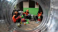 Petugas Unit Penanganan Sampah  Badan Air Dinas Lingkungan Hidup membuat karya seni dari limbah botol plastik di Waduk Elok, Cakung, Jakarta Timur.  
