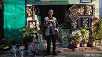 Sutrisno seorang seniman yang sering membuat karya seni dari sampah anorganik berpose di depan tokonya kawasan Tanjung Priok, Jakarta Utara.  