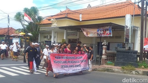 Sejumlah krama membentangkan spanduk Kami Mendukung agar Ngadegang Penghulu Desa Sesuai Awig-Awig berjalan menuju Pura Desa Kubutambahan, Selasa (13/5/2025). (Foto: Made Wijaya Kusuma/detikBali)