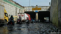 Banjir yang merendam kedua arah jalan membuat banyak pengendara motor dan mobil terjebak.