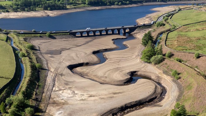 Waduk Inggris Dilanda Kekeringan, Terparah dalam 69 Tahun A drone view shows vehicles using a bridge to pass over a partially dry section of the Woodhead Reservoir after a prolonged period without rain, which resulted in water levels dropping, near Tintwistle, Britain, May 13, 2025. REUTERS/Phil Noble