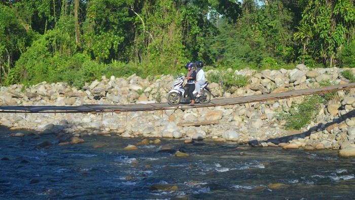 Jembatan darurat pasca banjir bandang tetap dimanfaatkan Warga menggunakan sepeda motor melewati jembatan darurat di Nagari Koto Rawang, Kecamatan IV Jurai, Pesisir Selatan, Sumatera Barat, Kamis (15/5/2025). Jembatan darurat yang dibuat pasca banjir bandang tahun lalu itu masih digunakan untuk akses utama bagi masyarakat setempat, walaupun kondisinya membahayakan. ANTARA FOTO/Iggoy el Fitra/Spt.