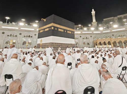 Jamaah calon haji dari berbagai negara bersiap menunaikan Shalat Isya dengan latar belakang Kabah yang telah diselimuti kain ihram di Masjidil Haram, Makkah, Arab Saudi, Rabu (15/5/2025) malam. Kain kiswah Kabah telah diangkat setinggi tiga meter dan selanjutnya dipasangi kain ihram di bagian bawahnya yang menandai dimulainya musim haji 1446 Hijriah/2025 Masehi. ANTARA FOTO/Andika Wahyu