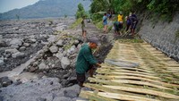 Relawan memasang jembatan bambu di jalur terdampak lahar hujan Gunung Semeru di Desa Jugosari, Kecamatan Candipuro, Lumajang, Jawa Timur, Kamis (15/5/2025).