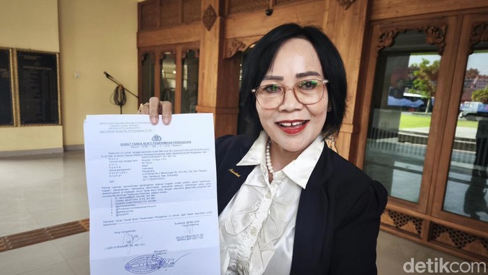 Pengacara Asri Purwanti saat menunjukan surat bukti aduan di Mapolresta Solo, Kamis (15/5/2025).