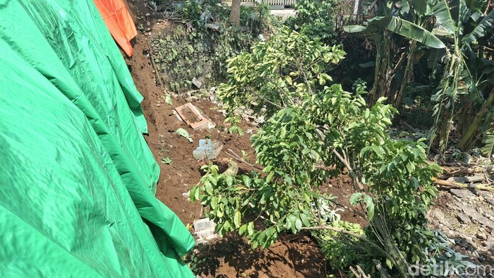 Sebanyak delapan makam di lahan pemakaman umum Batakal, Kelurahan Batutulis, Kota Bogor ambrol terbawa tanah yang longsor usai hujan deras. (M Sholihin/detikcom)