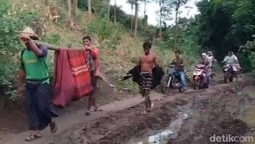 Warga Meang yang sedang sakit ditandu bergotong- royong oleh masyarakat, di desa persiapan Pengantap, Kecamatan Sekotong, Lombok Barat.