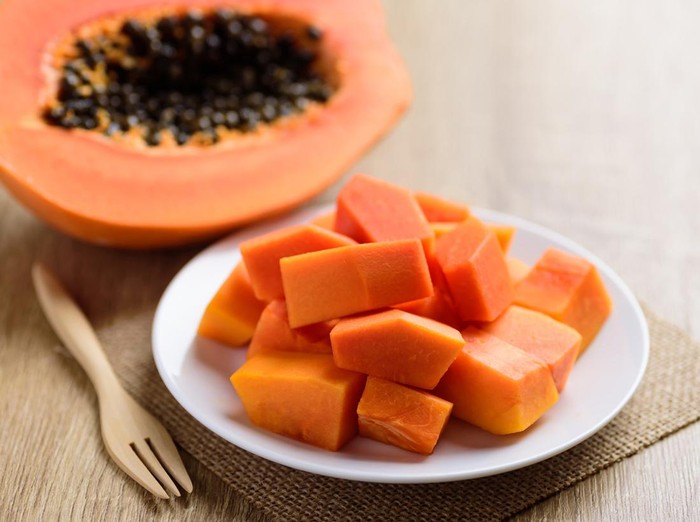 Sliced ripe papaya fruit on plate and fork ready to eating, Tropical fruit