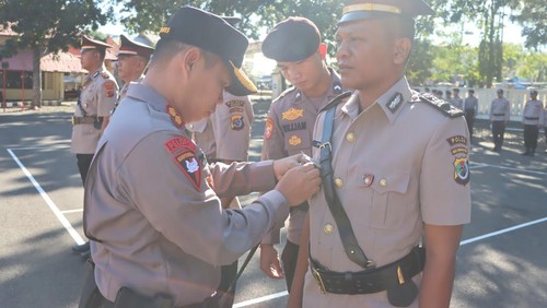 Kapolres Manggarai Barat AKBP Christian Kadang memasangksn pin jabatan p aat upacara pelantikan dan sertijab di Mapolres Manggarai Barat, Jumat (16/5/2025). (Dok. Humas Polres Manggarai Barat)