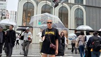 Kimmy berpose di zebra cross Ginza Six, Tokyo. Gerimis gak jadi penghalang buat Kimmy tetap bergaya memakai kaus hitam dipadukan dengan celana mini putih, sepatu boots, dan sambil memegang payung transparan. Foto: dok. Instagram Kimmy Jayanti