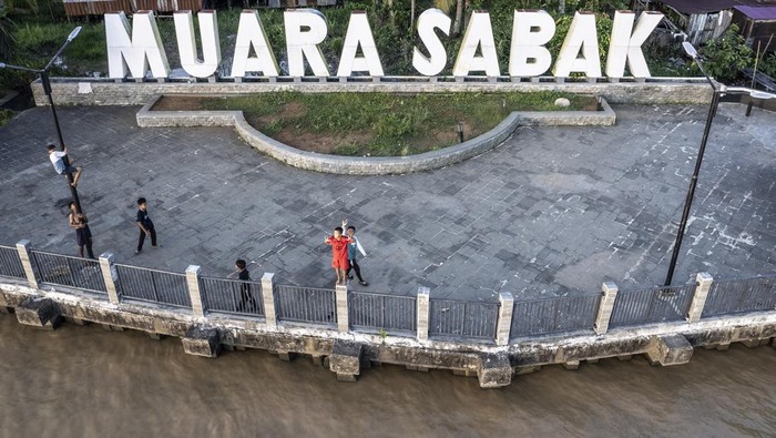 Pelabuhan Muara Sabak Disulap Jadi Destinasi Wisata Sejarah Foto udara perahu melintasi Sungai Berbak di samping Ruang Terbuka Hijau (RTH) Muara Sabak, Muara Sabak Ulu, Tanjung Jabung Timur, Jambi, Kamis (15/5/2025). Pemerintah Kabupaten Tanjung Jabung Timur berencana mengembangkan kawasan bekas Pelabuhan Muara Sabak tersebut sebagai salah satu tempat pengembangan wisata sejarah dan budaya yang dimulai dengan pembangunan RTH. ANTARA FOTO/Wahdi Septiawan