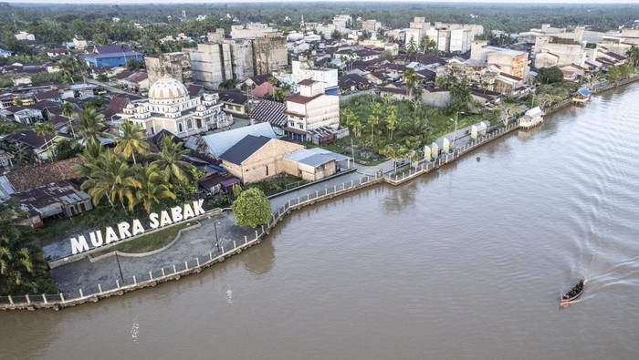 Pelabuhan Muara Sabak Disulap Jadi Destinasi Wisata Sejarah Foto udara perahu melintasi Sungai Berbak di samping Ruang Terbuka Hijau (RTH) Muara Sabak, Muara Sabak Ulu, Tanjung Jabung Timur, Jambi, Kamis (15/5/2025). Pemerintah Kabupaten Tanjung Jabung Timur berencana mengembangkan kawasan bekas Pelabuhan Muara Sabak tersebut sebagai salah satu tempat pengembangan wisata sejarah dan budaya yang dimulai dengan pembangunan RTH. ANTARA FOTO/Wahdi Septiawan