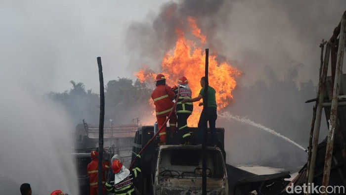 Petugas Damkar melakukan pemadaman gudang minyak ilegal yang terbakar di Jambi