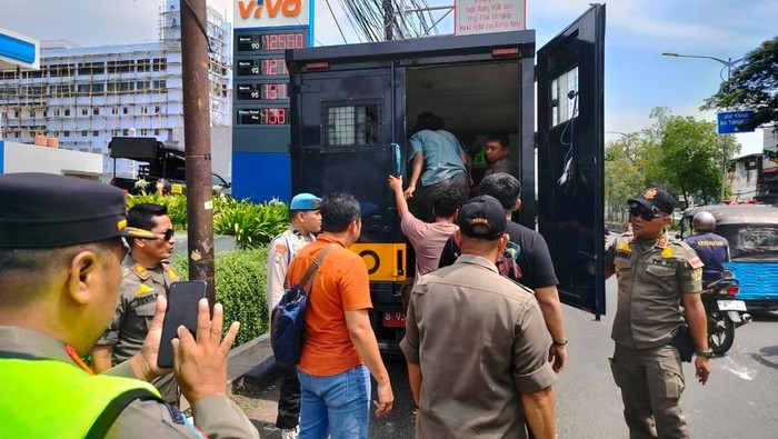 Polisi dan Satpol PP menertibkan atribut ormas di Jakbar, 10 juru parkir liar turut diamankan.