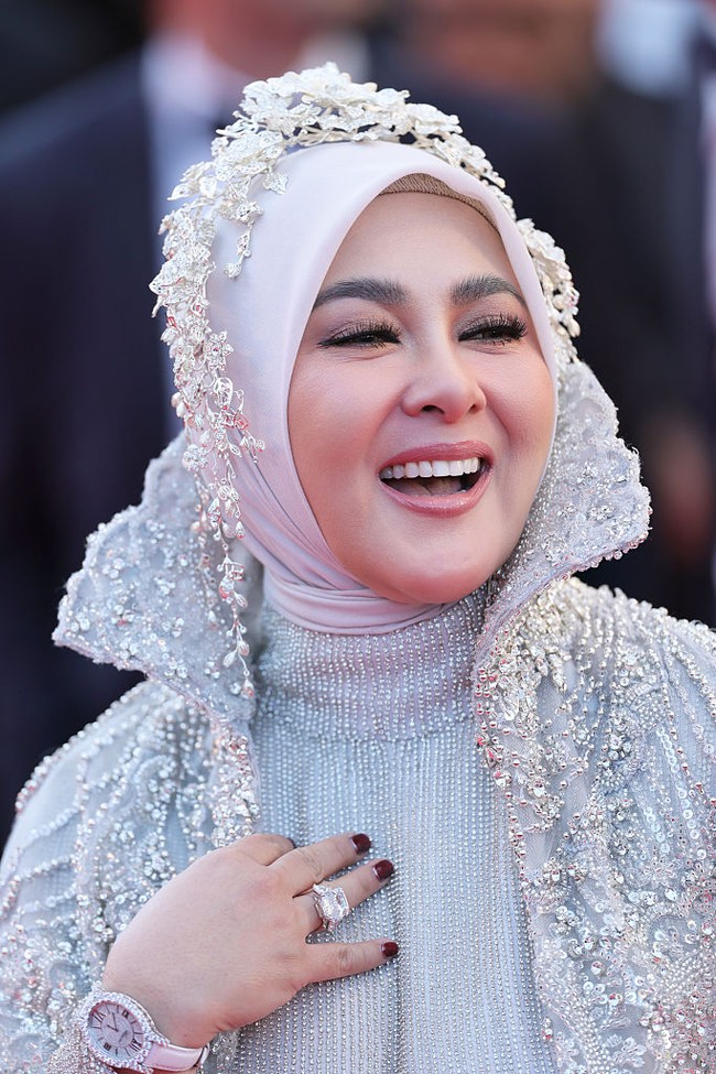 Hijab putih yang dikenakannya dihias dengan mahkota floral beaded karya desainer aksesori Rinaldy Yunardi. Untuk melengkapi penampilannya, Syahrini membawa clutch kulit bertekstur buaya, serta cincin statement di jari-jarinya yang mempertegas aura glamor. Foto: Getty Images/Vittorio Zunino Celotto
