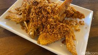 Ayam goreng berbumbu Thailand (Rp 50.000) juga menjadi menu favorit dari Ban Thai atau Nana Thai Baan. Ini juga menu yang ditawarkannya melalui online 10 tahun lalu. Bisa disajikan dengan potongan wings atau paha yang juicy. Foto: detikFood/Yenny Mustika Sari