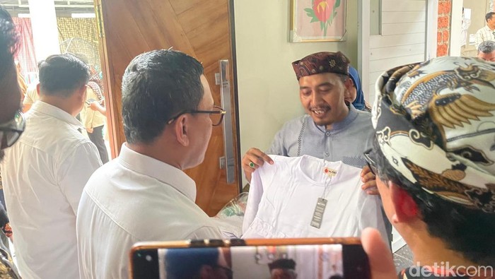 Didi Kusnadi saat menunjukkan pakaian muslim kepada Menteri Perlindungan Pekerja Migran Indonesia, Abdul Kadir Karding