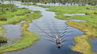Foto udara penjual elpiji pangkalan membawa elpiji 3 kg menggunakan perahu ketinting menyusuri Danau Melintang di Desa Enggelam, Kecamatan Muara Wis, Kabupaten Kutai Kartanegara, Kalimantan Timur, Sabtu (17/5/2025). Perjalanan itu menjadi bagian dari upaya rutin untuk memastikan warga di wilayah terpencil tetap mendapatkan akses energi yang terjangkau.
