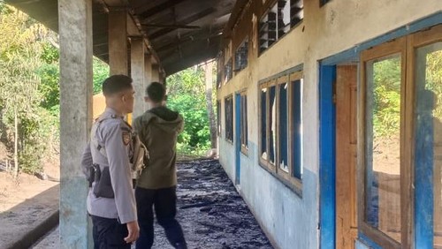Dua polisi mengecek sekolah yang terbakar di Lembata, Jumat (17/5/2025).