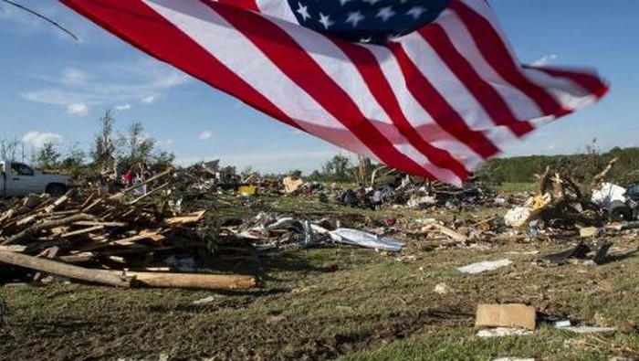 LONDON, KENTUCKY - MAY 17: An American flag flies over debris from a tornado that ripped through the neighborhood of Sunshine Hills on May 17, 2025 in London, Kentucky. A tornado struck communities in Somerset and London, Kentucky, leaving over 10 dead and more injured.   Michael Swensen/Getty Images/AFP (Photo by Michael Swensen / GETTY IMAGES NORTH AMERICA / Getty Images via AFP)