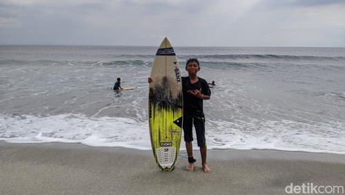 Anak-anak Dusun Kerandangan, Desa Senggigi, Kecamatan Batulayar, Lombok Barat, NTB, bermain selancar di pantai Kerandangan I, Minggu (18/5/2025). (Ahmad Viqi/detikBali).