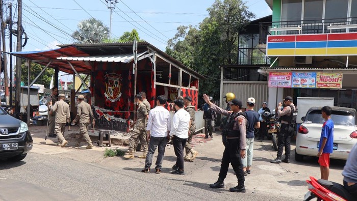 Aparat menertibkan atribut organisasi kemasyarakatan (ormas) dan posko ormas yang tidak sesuai izin mendirikan bangunan (IMB) di Kota Depok. (dok Istimewa)