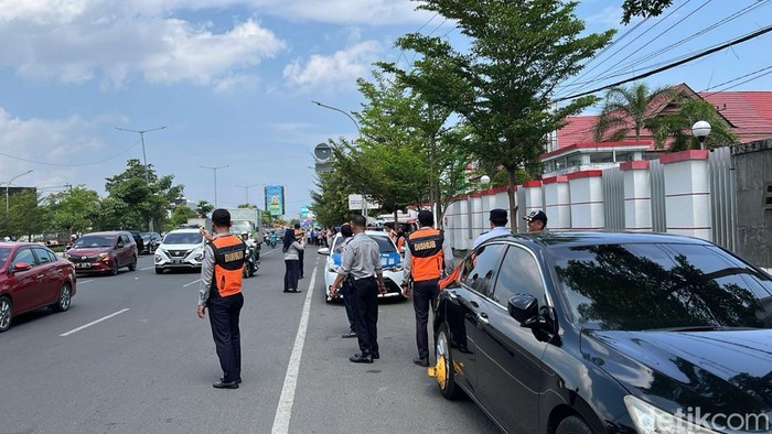 Dishub Makassar menggembok mobil parkir di bahu jalan.