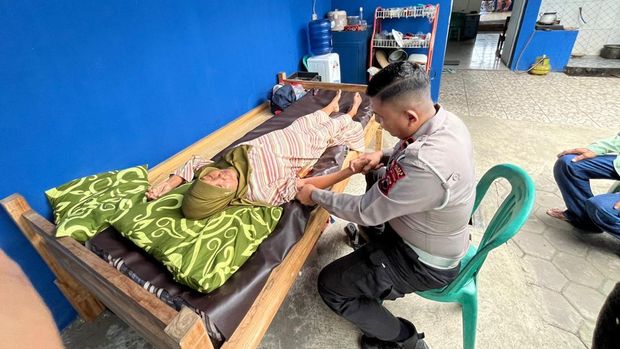 Kanit Lantas Polsek Gombong, Ipda Lanjar Pamuji, saat melayani pengobatan alternatif.