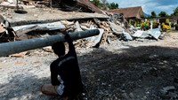 Petugas dan warga mulai mengevakuasi puing-puing sisa longsor yang merusak bangunan di Nagreg, Bandung, sehari setelah bencana terjadi.