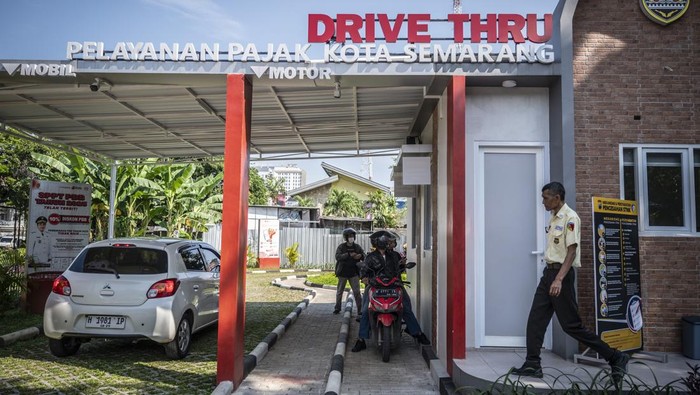 Petugas (kanan) melayani pengendara sepeda motor membayar pajak kendaraan bermotor di Layanan Drive Thru Pajak Daerah Kota Semarang, Jawa Tengah, Senin (19/5/2025). Kementerian Keuangan melaporkan realisasi penerimaan pajak hingga triwulan I 2025 mencapai Rp322,6 triliun, atau sekitar 14,7 persen dari target pajak 2025 sebesar Rp2.433,5 triliun. ANTARA FOTO/Aprillio Akbar