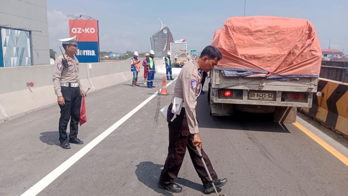 Polisi melakukan olah TKP truk terbalik di Jalan Tol Layang AP Pettarani Makassar.