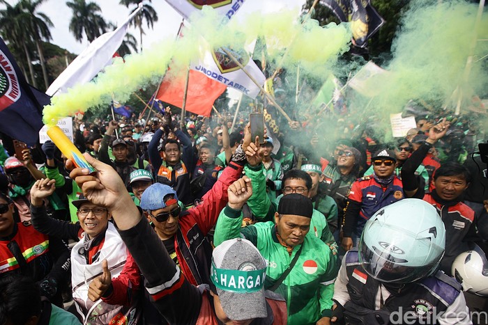 Ratusan ojol demo di Patung Kuda tuntut komisi 10% dan desak pemerintah sahkan UU Transportasi Online. Jalan Medan Merdeka pun dikuasai para ojol.
