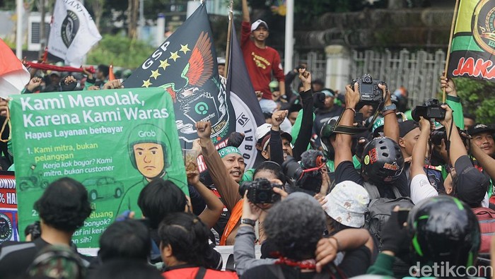 Aksi Ojol Kuasai Jalan Merdeka Selatan Ratusan ojol demo di Patung Kuda tuntut komisi 10% dan desak pemerintah sahkan UU Transportasi Online. Jalan Medan Merdeka pun dikuasai para ojol.