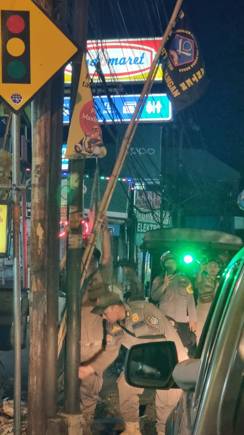 Aparat gabungan di Sawangan, Kota Depok menertibkan atribut organisasi kemasyarakatan (ormas) yang mengganggu di fasilitas umum. (dok Istimewa)